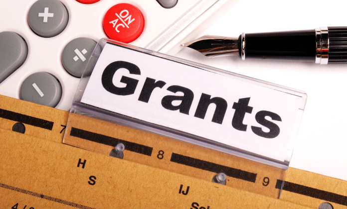 Grants file, calculator and pen, grants and funding